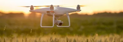 Drown flying over field at sunrise