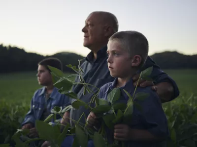 MAn on fiel with children 