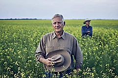 Man in field holding hat