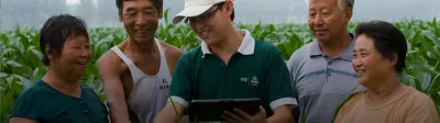 Representative in field with farmers
