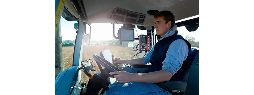 Young man drives tractor