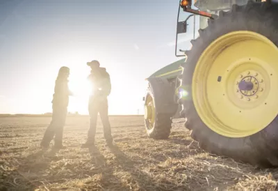 farmers on combine at sunrise