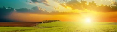 sunrise over meadow with blue sky